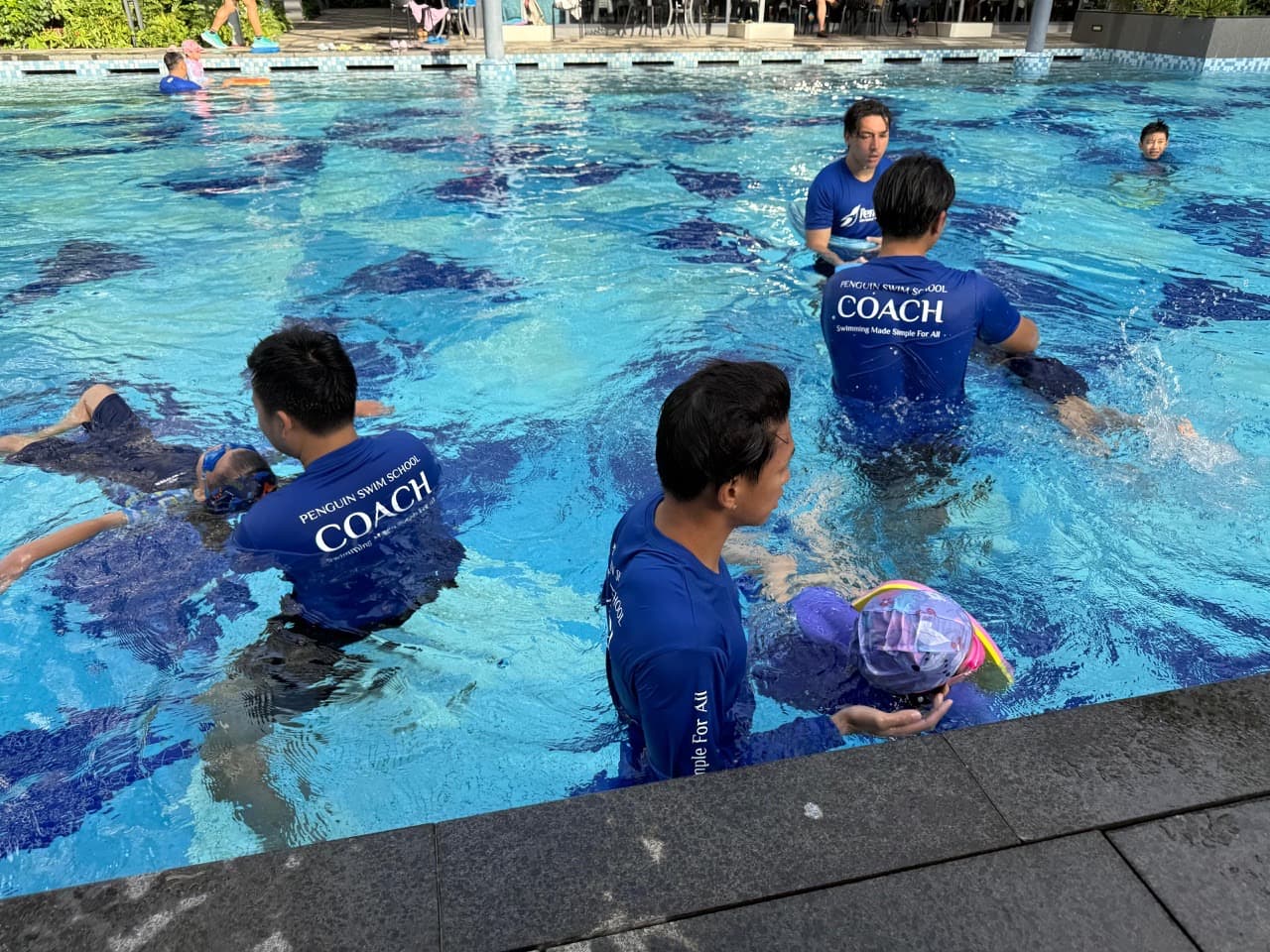 Penguin Academy coach providing close, supervised instruction during a swim session